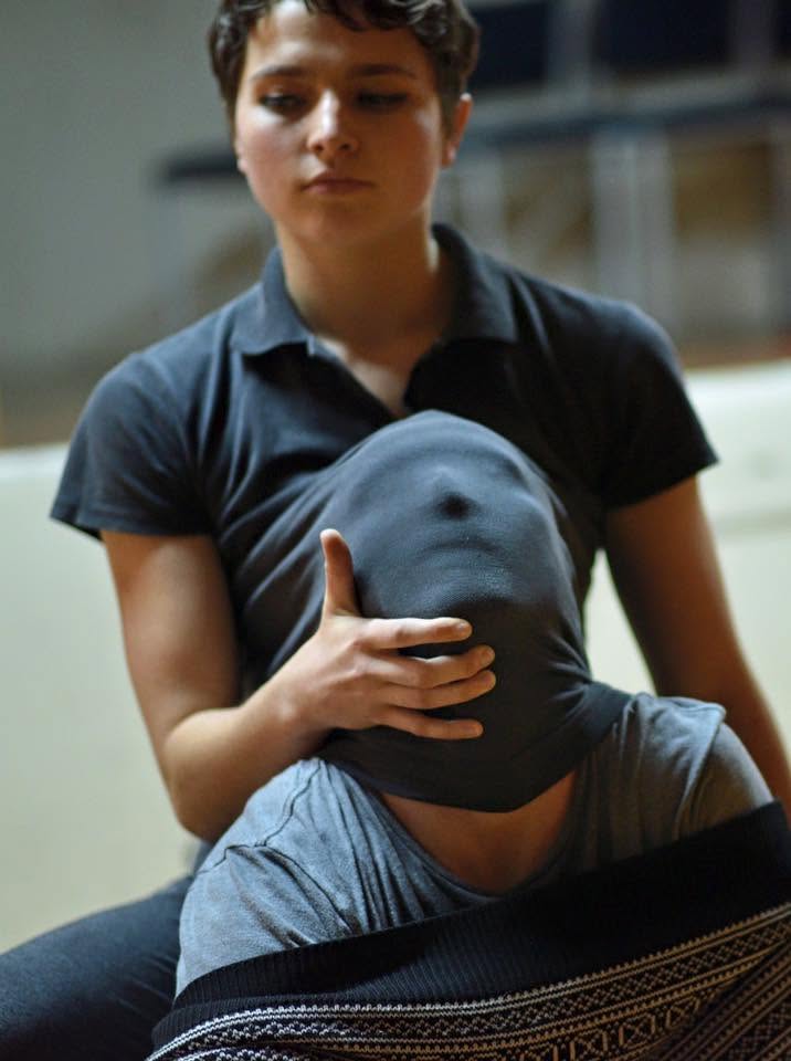 Two performers exploring touch and concealment in rehearsal